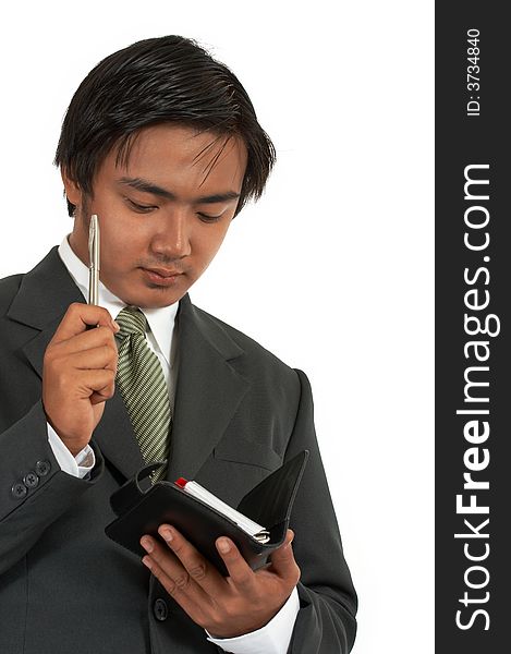 Businessman writing on his personal organizer over a white background