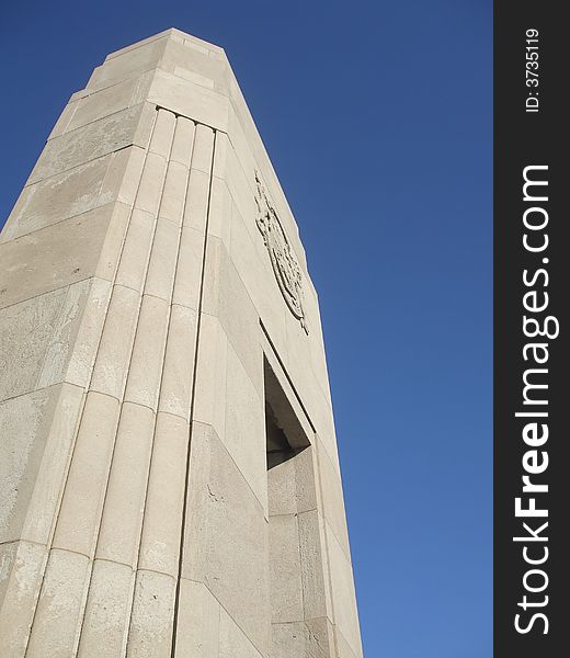 A carved stone pillar against a clear, blue sky. A carved stone pillar against a clear, blue sky.