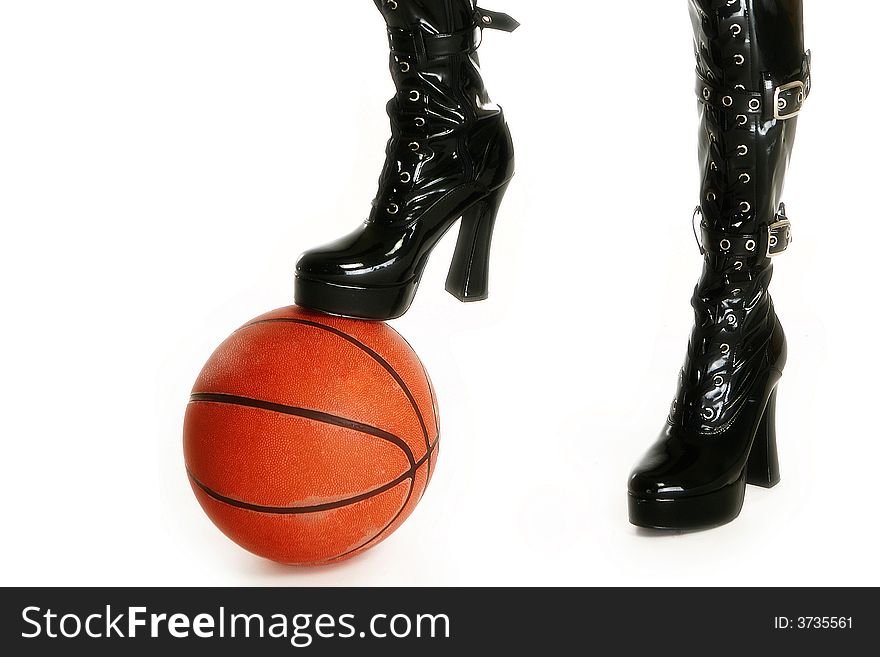 Female legs in thigh high vinyl boots with basketball over white. Female legs in thigh high vinyl boots with basketball over white.