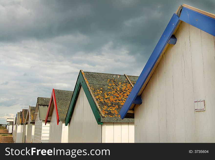 Line of beach hut roofs on a cloudy day