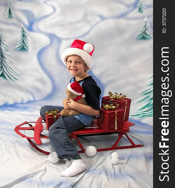 A young boy riding on a sled with all his christmas presents. A young boy riding on a sled with all his christmas presents.