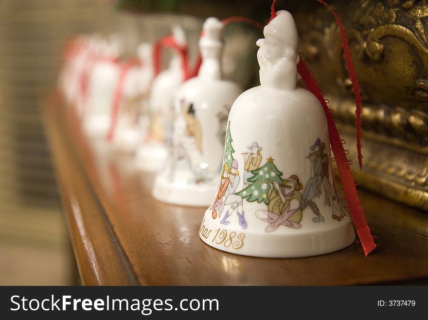 A line of ceramic Christmas bells on a shelf