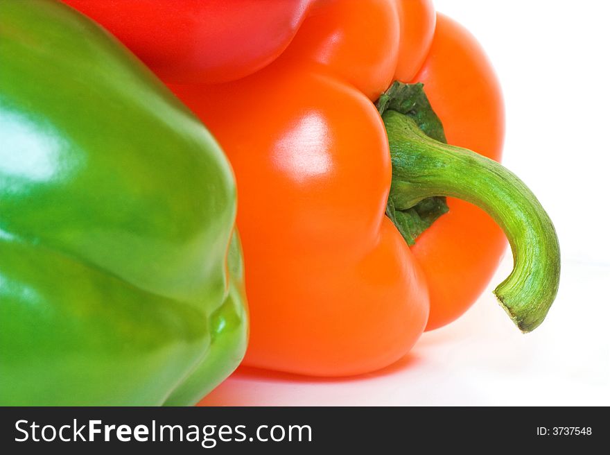 Closeup detail of shiny fresh bell peppers; red green and orange.