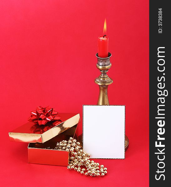 Christmas candle with flame. A white card in front. Red background. Christmas candle with flame. A white card in front. Red background.