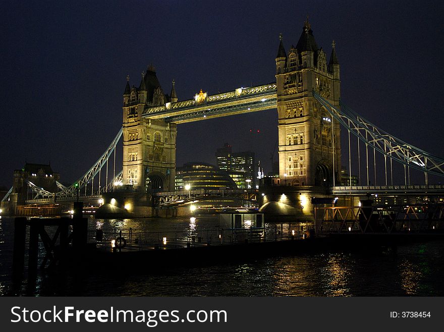 Tower bridge with all its lights on taken opposite Butlers wharf, with St Katharines pier in the foreground. Tower bridge with all its lights on taken opposite Butlers wharf, with St Katharines pier in the foreground