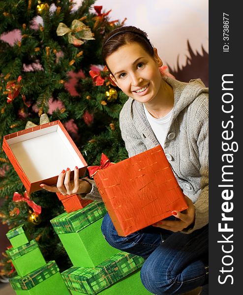 Teenager girl with gift boxes, Christmas three behind her