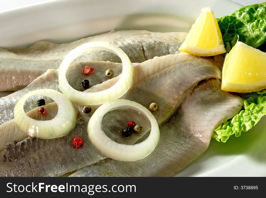 Arranged herrings with onion rings and lemon