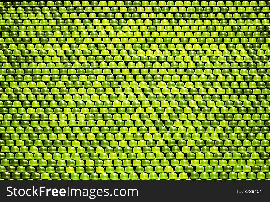 An abstract background of empty green stadium seats