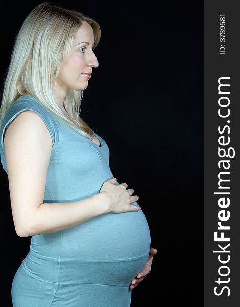 Happy pregnant woman standing on black