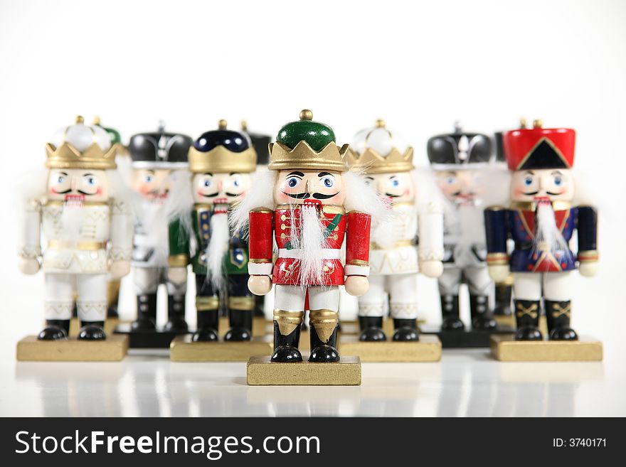 A whimsical group of holiday nutcrackers isolated on a white background. Shallow DoF with focus on front nutcracker. Holiday concept. A whimsical group of holiday nutcrackers isolated on a white background. Shallow DoF with focus on front nutcracker. Holiday concept.