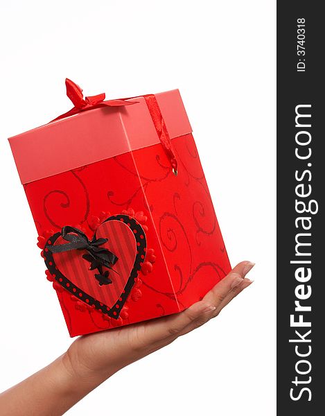 A hand holding a red gift box
