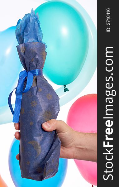 A hand holding wrap bottle over the balloons. A hand holding wrap bottle over the balloons