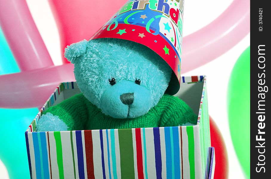 Teddy bear inside the multi color box over the balloon. Teddy bear inside the multi color box over the balloon