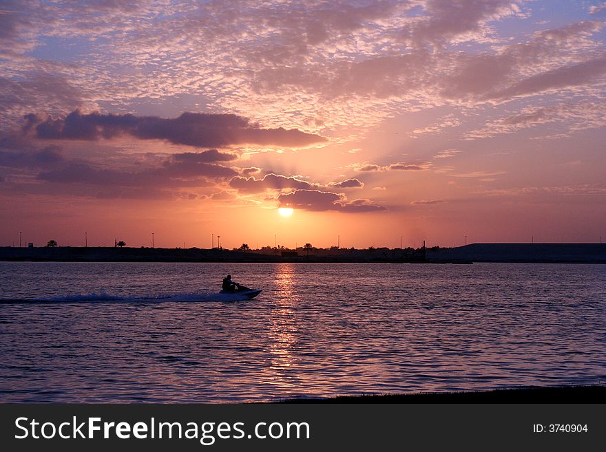 A speedboat with sunset in the background. A speedboat with sunset in the background