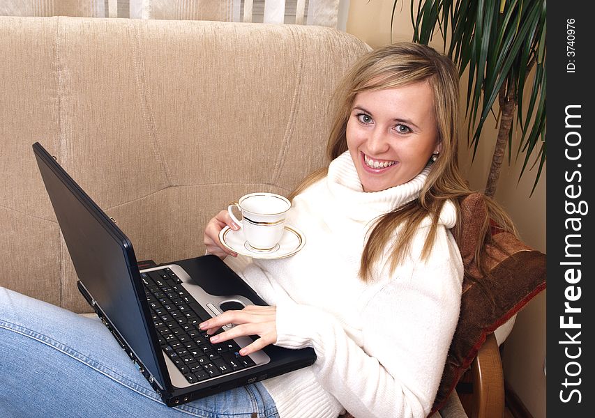 Young Woman Sitting On The Sofa And Working.