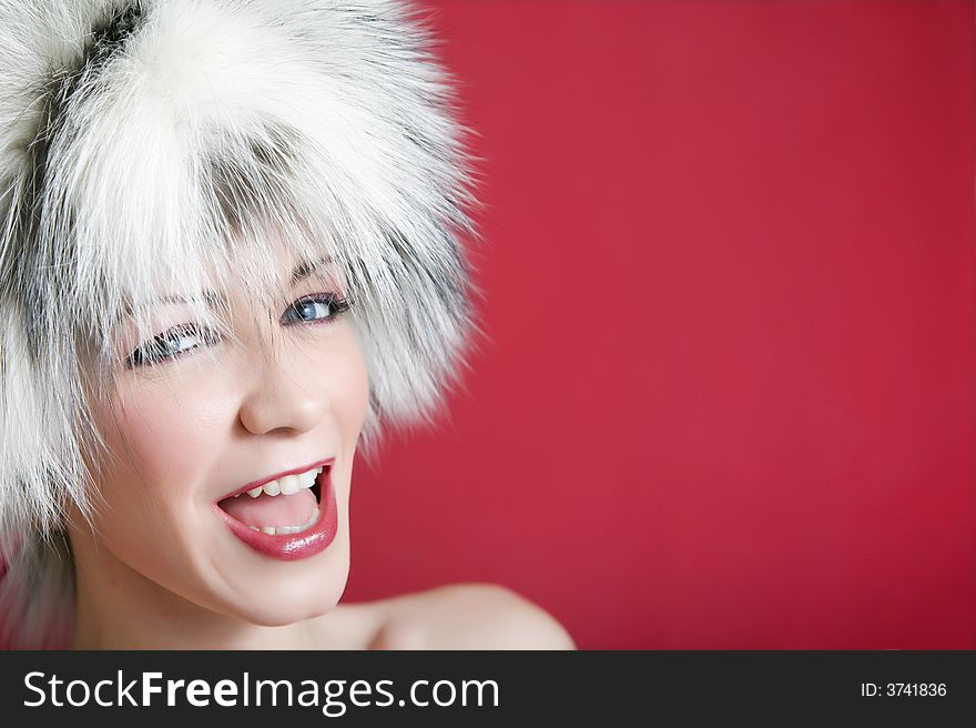 Winter scene: young girl in fur on a red background