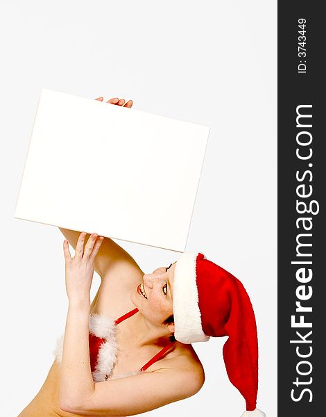 Beautiful girl in christmas bikini and with christmas hat is holding up a white sign for copy space. With background clipping path for your convenience. Beautiful girl in christmas bikini and with christmas hat is holding up a white sign for copy space. With background clipping path for your convenience