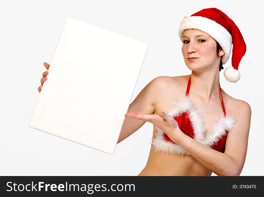 Beautiful girl in christmas bikini and with christmas hat is holding up a white sign for copy space. With background clipping path for your convenience. Beautiful girl in christmas bikini and with christmas hat is holding up a white sign for copy space. With background clipping path for your convenience