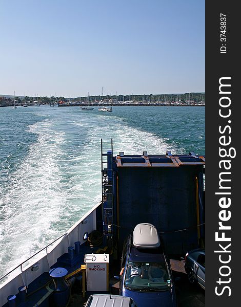 Back of car ferry leaving port with wake. Back of car ferry leaving port with wake