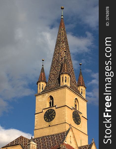 The Tower of the Evangelic Church in Sibiu, (European Capital of Culture 2007) with blue sky and clouds in the background. The Tower of the Evangelic Church in Sibiu, (European Capital of Culture 2007) with blue sky and clouds in the background