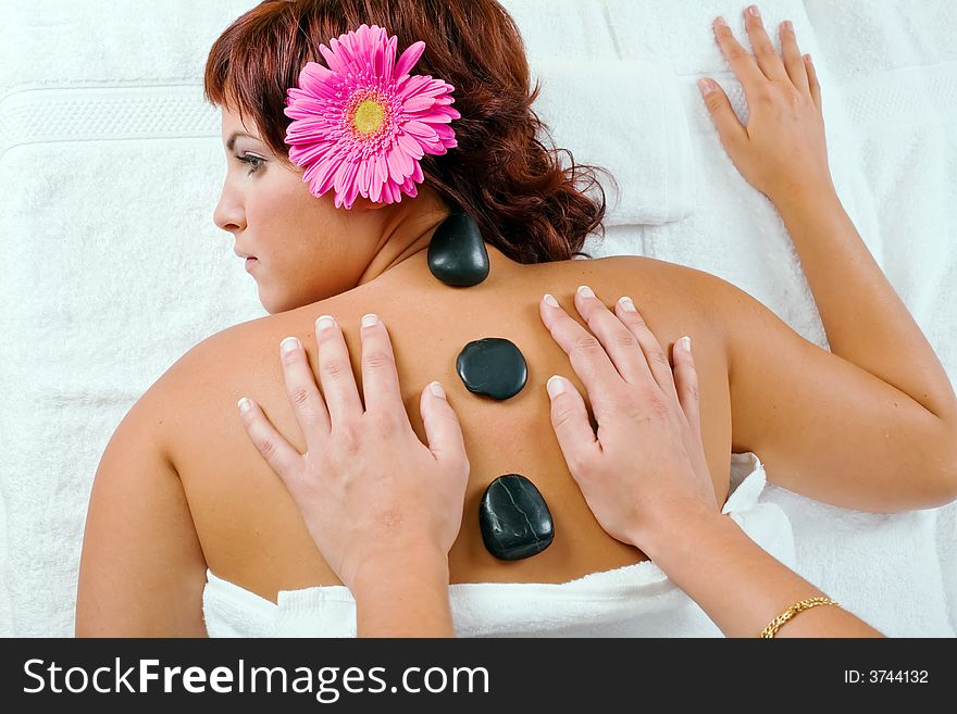 Young woman relaxing in spa salon with hot stones. Young woman relaxing in spa salon with hot stones