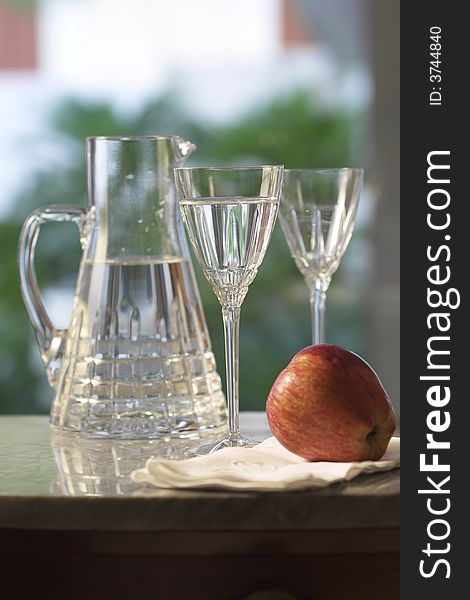 Carafe Of Water With Glasses And Apple