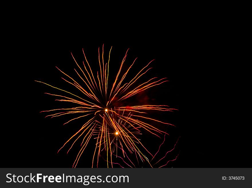 Red, white, yellow fireworks over dark sky