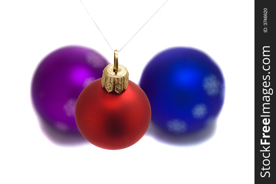 Christmas red fir ball over two another balls, isolated on white