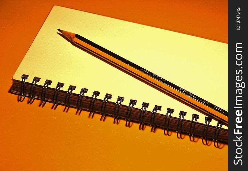 A pencil and a notebook. A pencil and a notebook.
