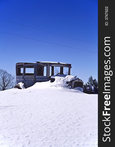 Old car in a snow & blue sky