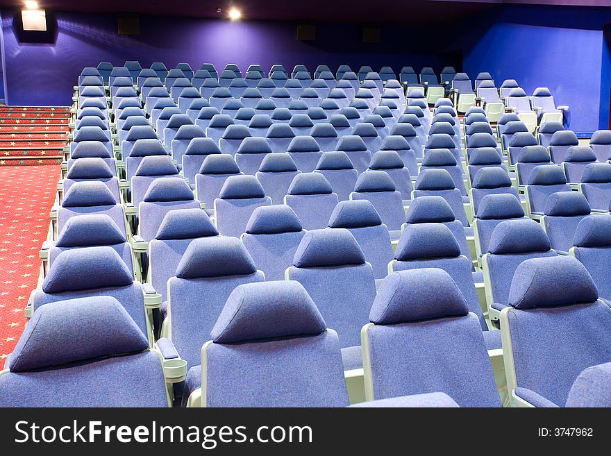 Empty cinema auditorium with blue chairs