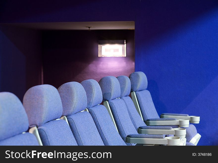 Empty cinema auditorium with blue chairs