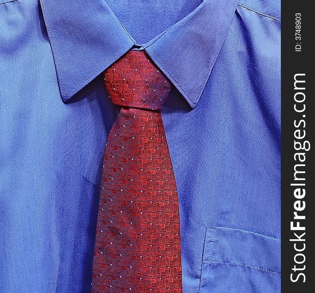 Fragment of masculine clothes. Dark blue shirt and large red tie.