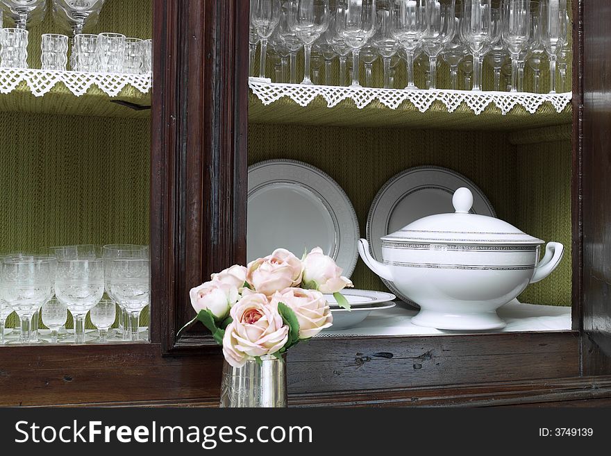Old style wooden cabinet with crystal glasses dishes and soupier. Old style wooden cabinet with crystal glasses dishes and soupier