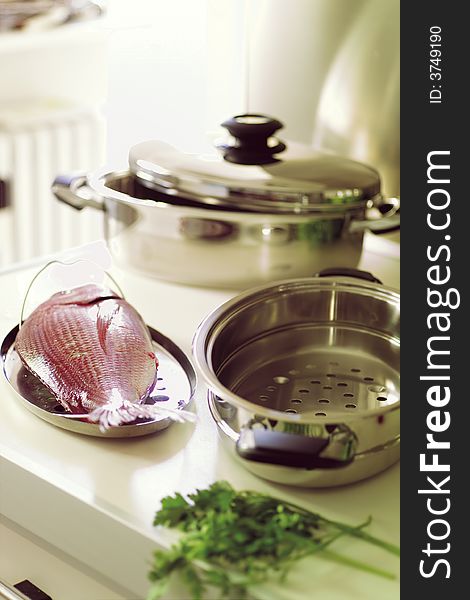 Country Kitchen, preparing a meal with fish in stainless steel pot. Country Kitchen, preparing a meal with fish in stainless steel pot