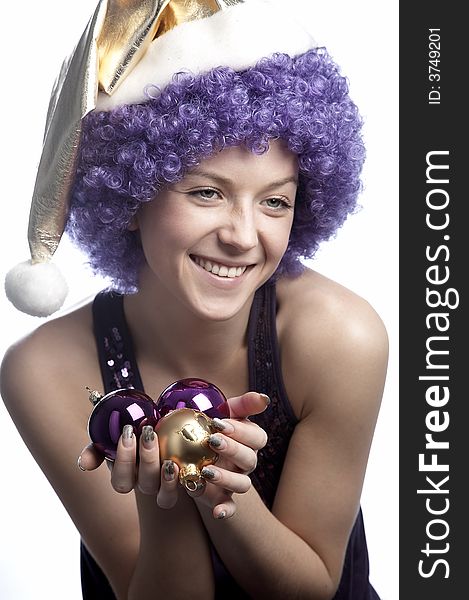 Girl in santa's hat and purple wig with christmas balls. Girl in santa's hat and purple wig with christmas balls