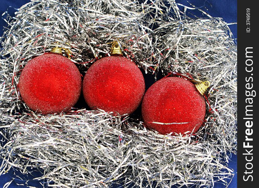 Three red xmas decorations on tinsel. Three red xmas decorations on tinsel.