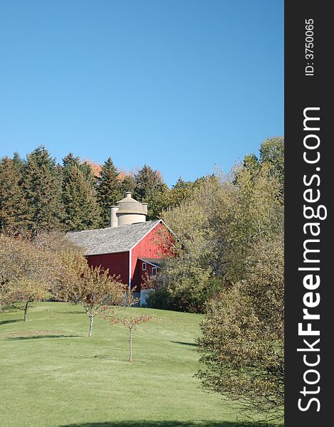 Red barn set on a holling hill with autumn fall foliage. Red barn set on a holling hill with autumn fall foliage