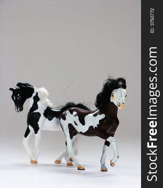 Two plastic toy horses on a white background. Two plastic toy horses on a white background