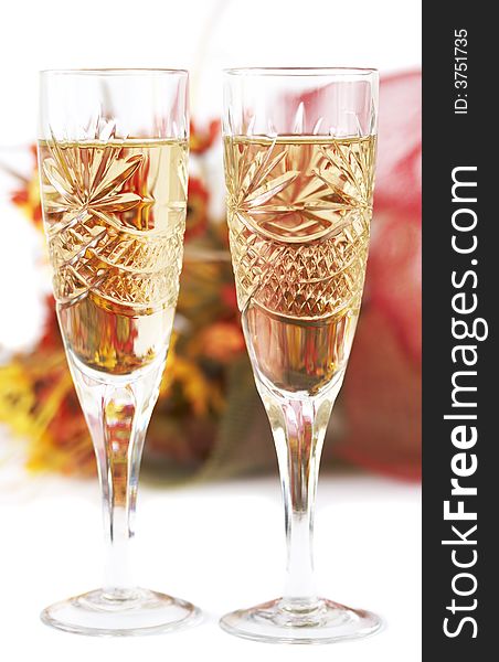 Two wineglasses with flowers as background