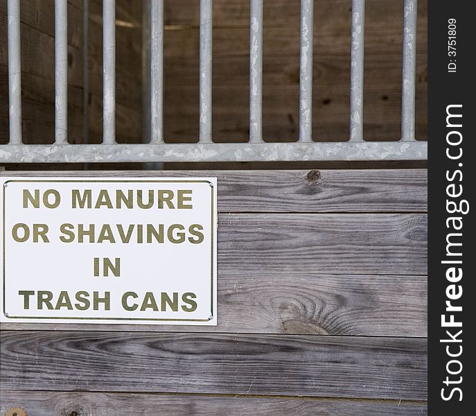 An old stable or barn with sign saying no manure or shavings in trash cans