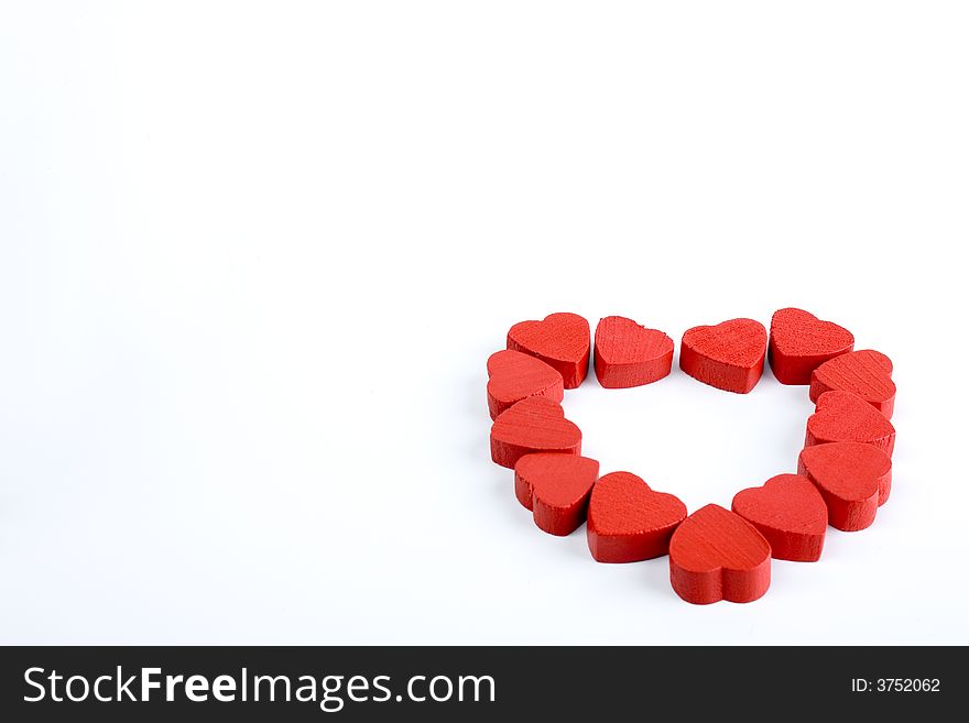 Just some small wooden red hearts lying together in a bigger heartshape on white background. Just some small wooden red hearts lying together in a bigger heartshape on white background.