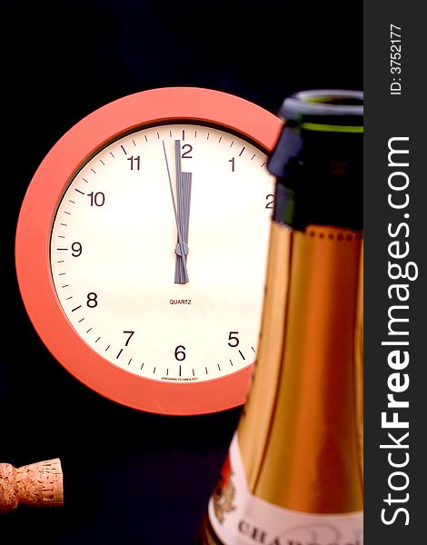 A clock ticking away the final seconds behind an uncorked bottle of champagne, shallow DOF, focus is on the clock