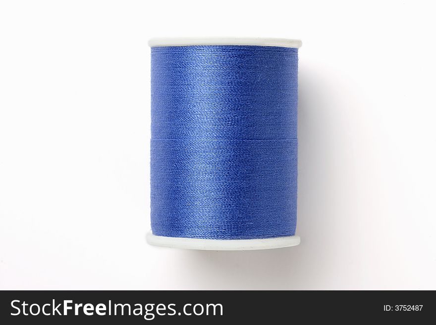 Spindle of blue thread isolated on white background