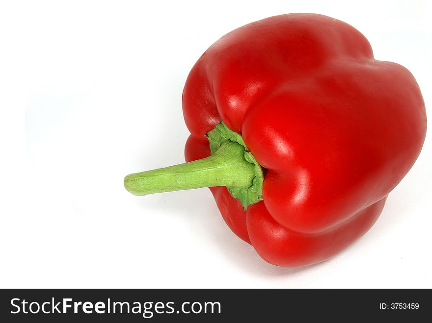 Isolated nice big red paprika with green tail against white. Isolated nice big red paprika with green tail against white