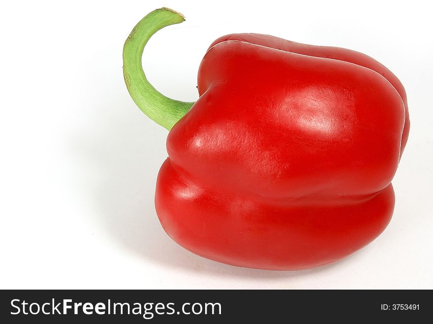 Isolated nice big red paprika with green tail against white. Isolated nice big red paprika with green tail against white