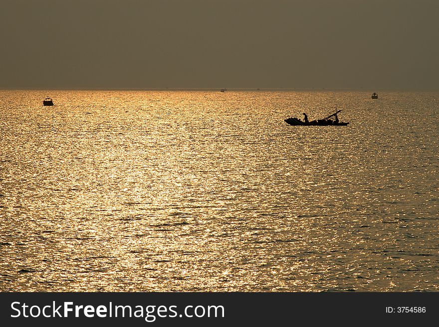 Sunset at sea with shipping boat silhouette,Clinquant.
