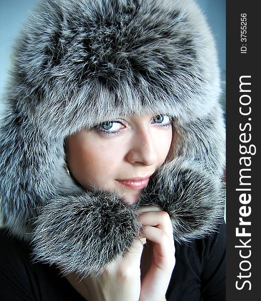 Beautiful girl in fur cap and blue eyes. Beautiful girl in fur cap and blue eyes