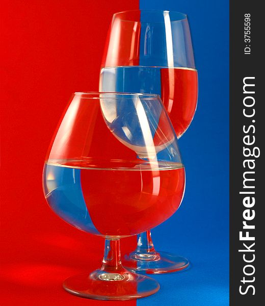 Two glasses on a blue-red background.