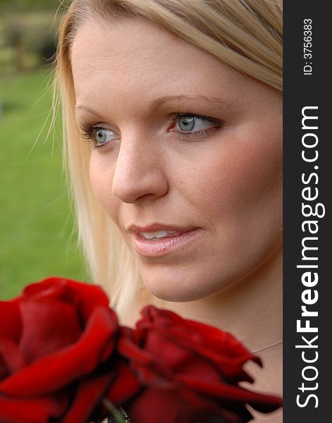 Portrait of blonde woman holding red roses. Portrait of blonde woman holding red roses.